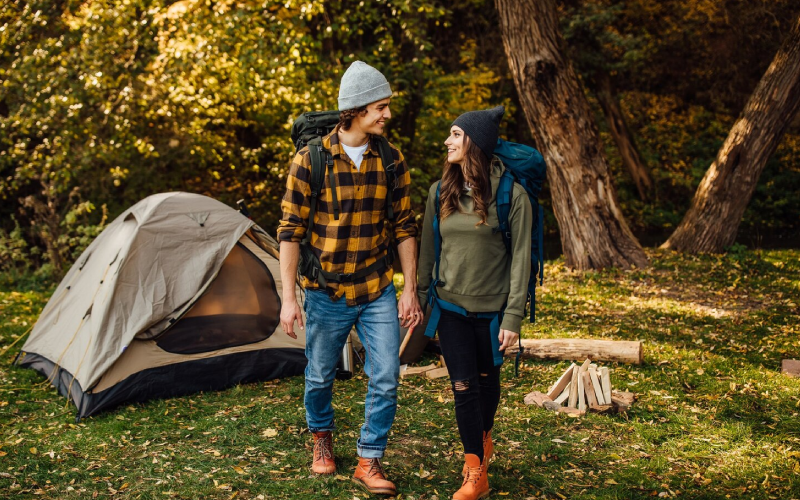 Young beautiful couple with hiking backpacks go camping